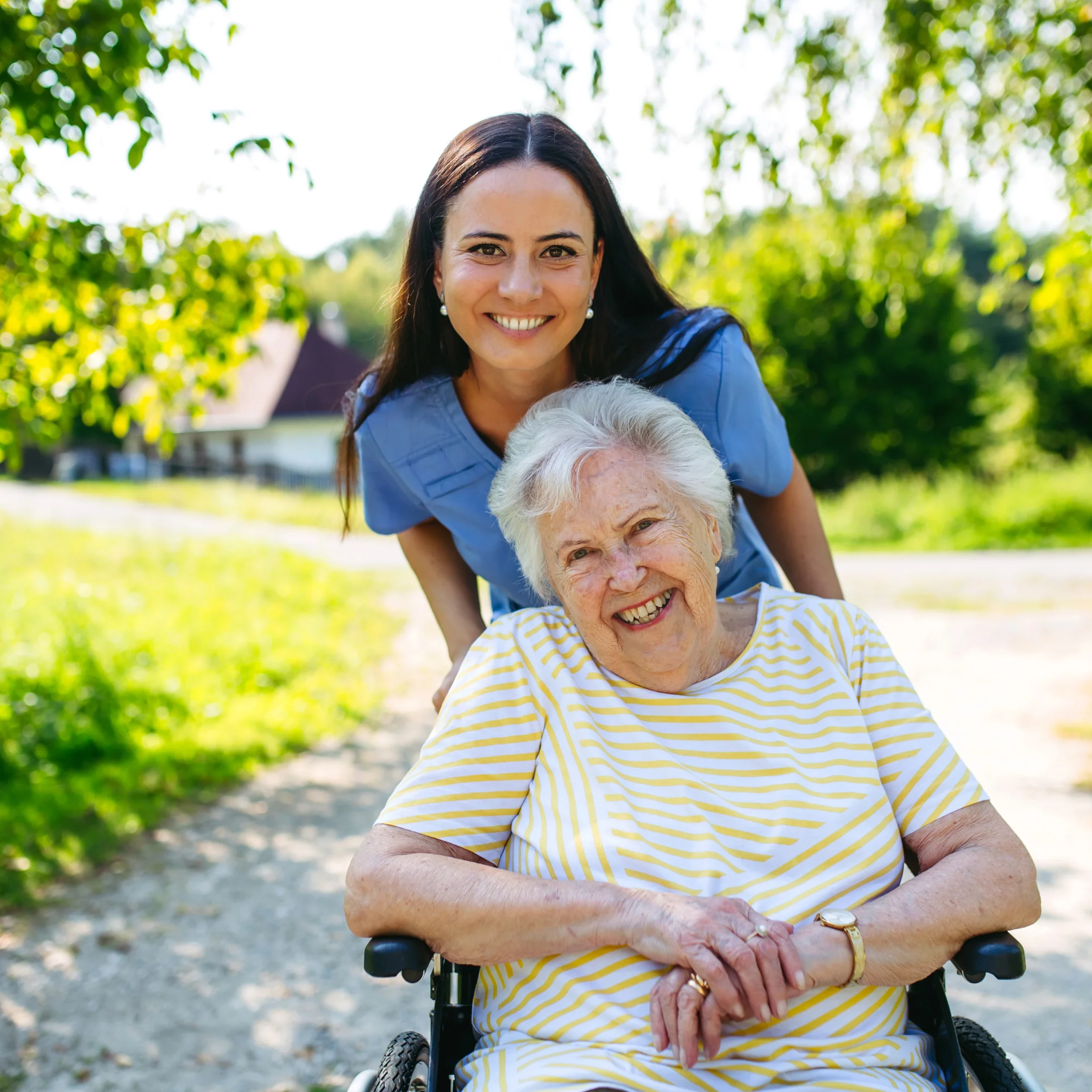 Anziana e assistente sorridono insieme all'aperto